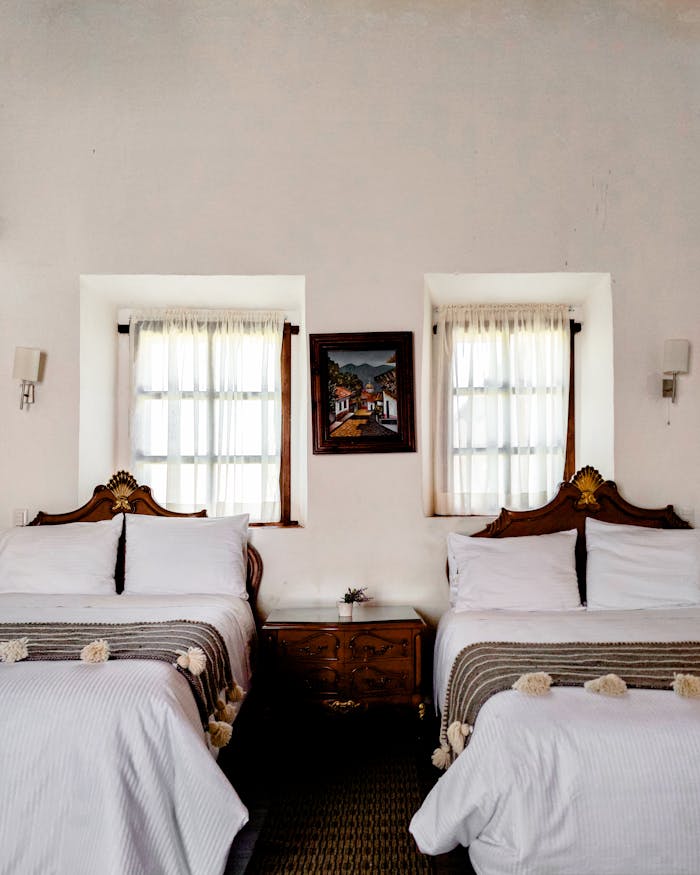 Luxurious hotel room featuring ornate twin beds and classic decor.